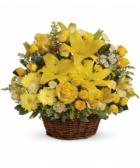 Bright yellow flowers and butterfly decoration in a wicker handbasket.