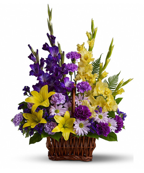 Yellow and purple flowers presented in a wicker basket