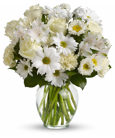 Clear glass vase filled with an assortment of all-white flowers